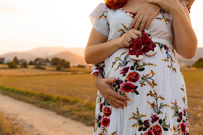 Babyschuhe am Babybauch im Abendlicht – Babybauchshooting, Bezirk Neunkirchen