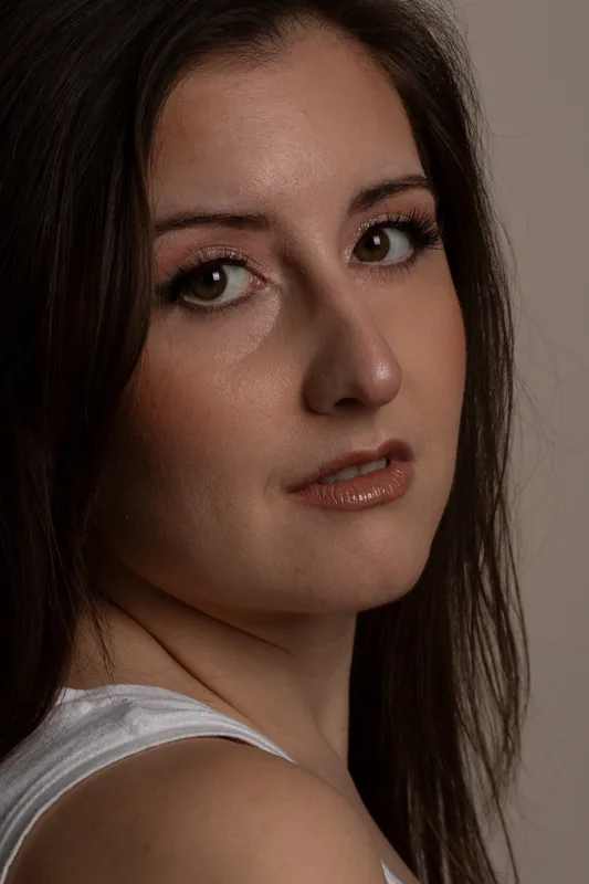 Studioportrait einer dunkelhaarigen Frau mit Blick über die Schulter – vorher, unbearbeitetes Original